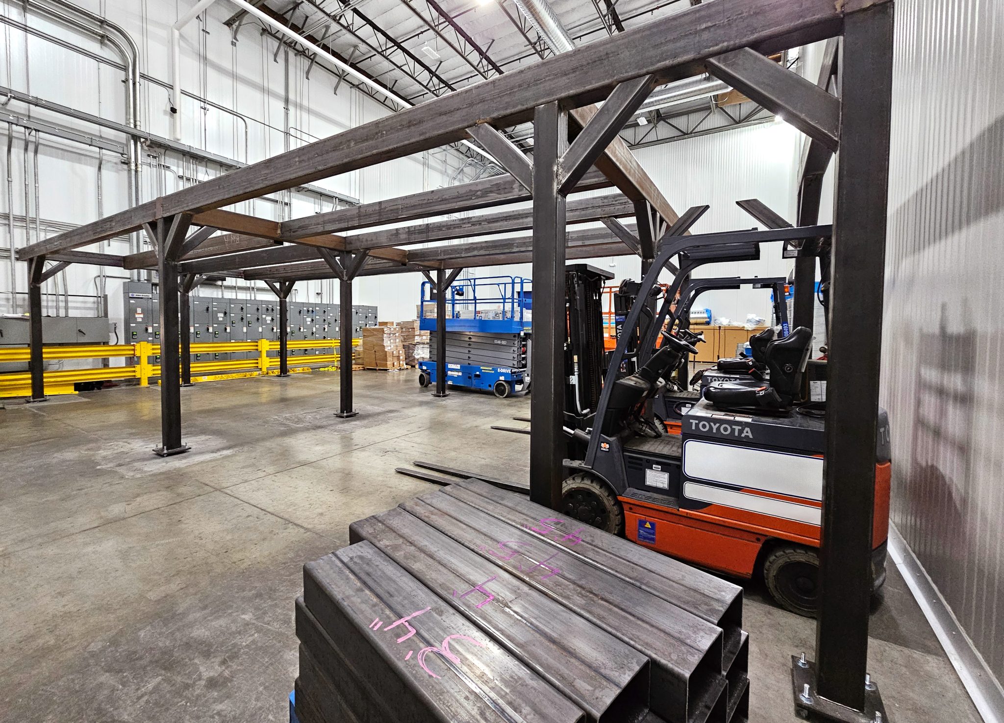 anchored carbon steel frame for structural mezzanine in food production facility